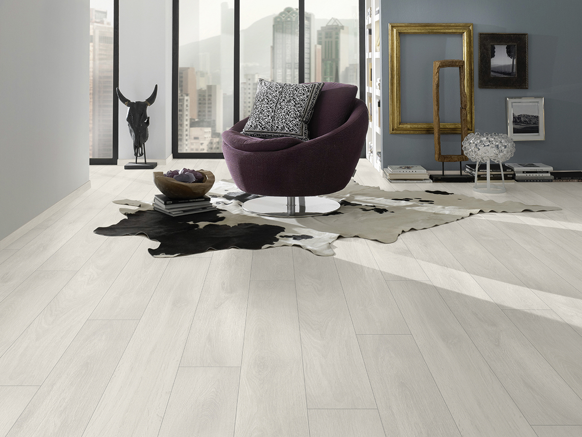 Aspen Oak laminate flooring in creative space with black-framed windows and dark furnishings – elegant contrast with light oak tone