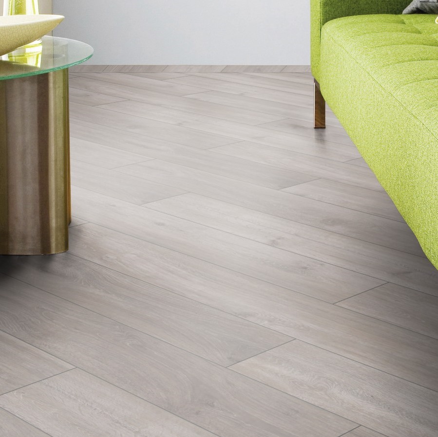 Close-up of Rockford Oak laminate flooring next to lime green sofa – grey oak texture creating bold modern contrast