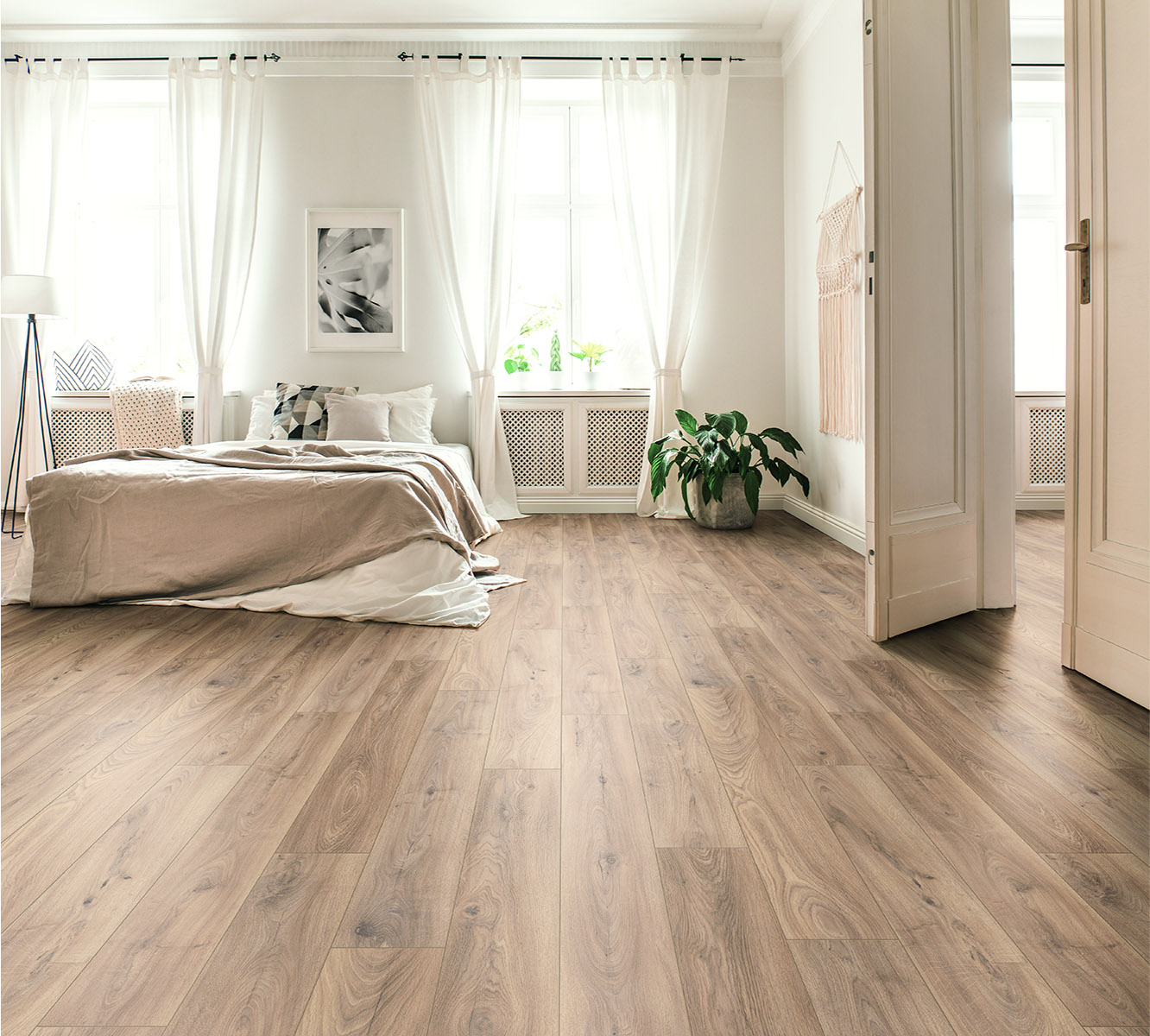 Firebrand Oak laminate flooring installed in a cozy bedroom – warm grey-beige tones creating a calm and elegant atmosphere