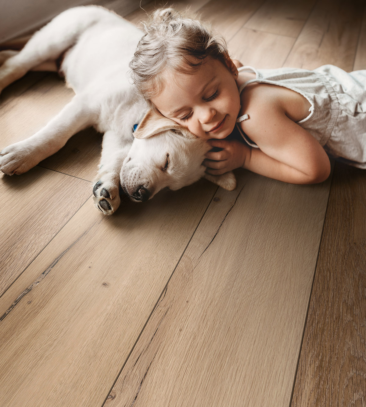 Girl and dog peacefully resting on K507 Hazel Range Oak flooring – warm, pet-friendly, and comfortable