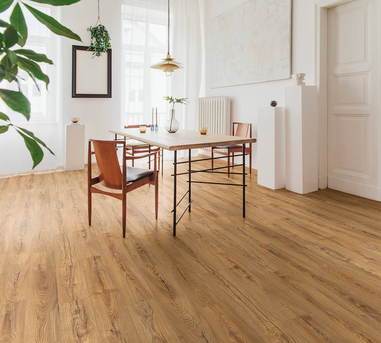 Inca Carpenter Oak laminate flooring in elegant dining room with white and oak decor – perfect harmony of rustic and modern