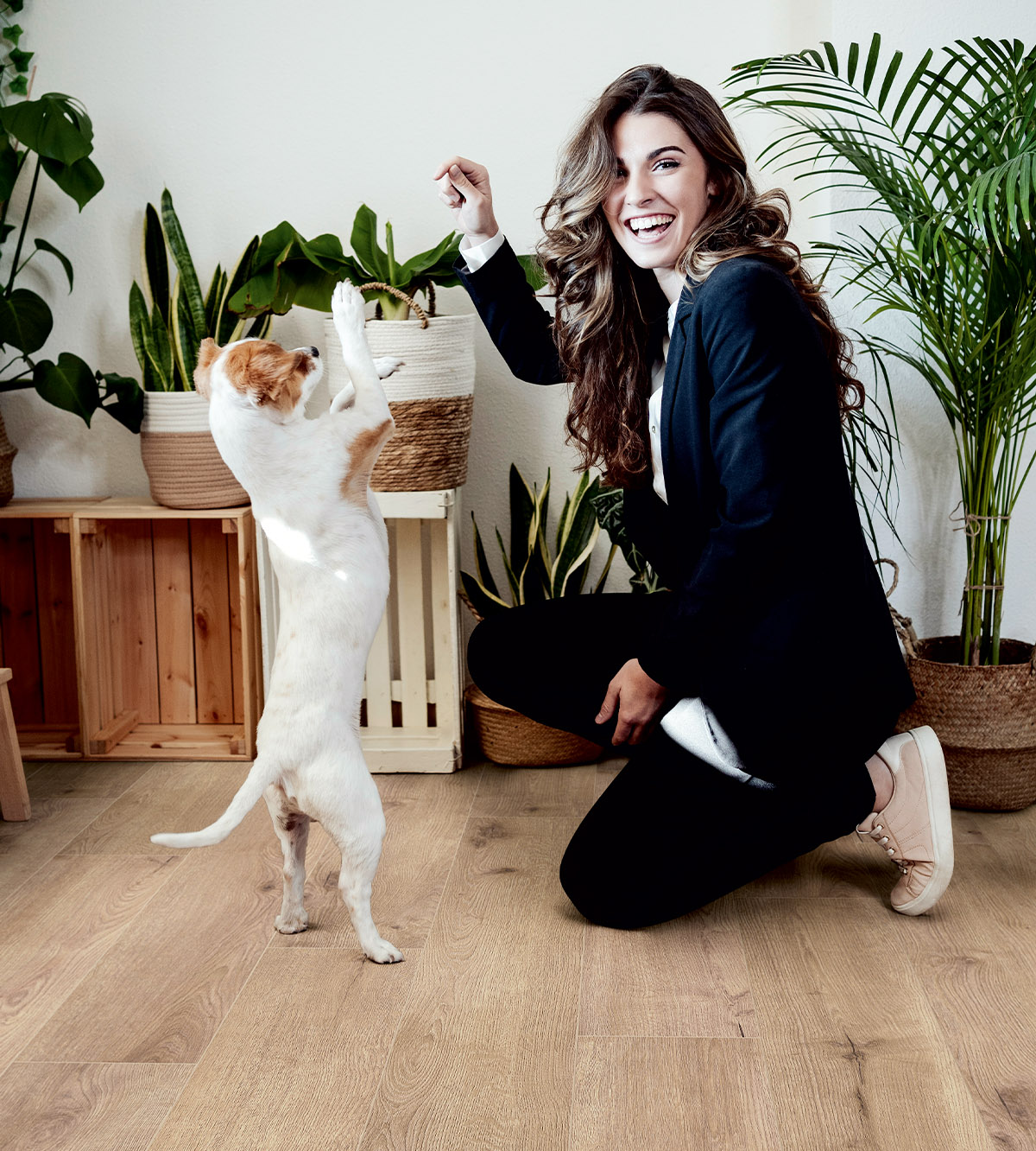 Woman playing with her dog on K501 Sand River Oak oak flooring – durable and pet-friendly surface