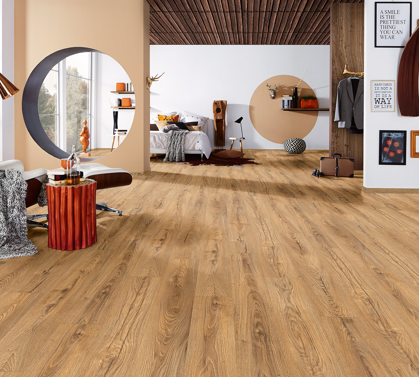 Inca Carpenter Oak laminate flooring in open-plan space with visible bedroom and dining zones – unifying rustic elegance