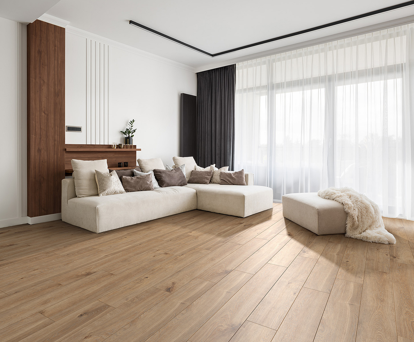 K405 Solar Oak flooring in a living room corner with white sofa – warm oak tones creating contrast with soft accents and light textiles